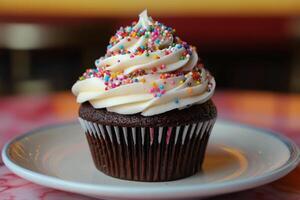 A chocolate cupcake with sprinkles on top photo