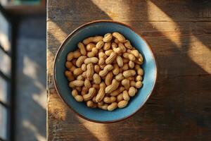 Peanuts in a bowl on a wooden table photo