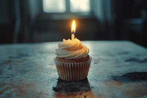 A cupcake with a single candle on top photo