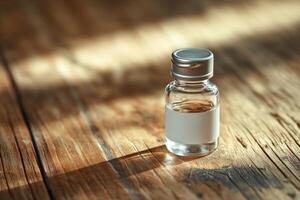 A small bottle of alcohol sitting on a wooden table photo