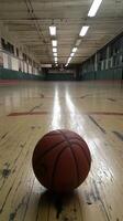 A basketball on the floor of an indoor gym photo