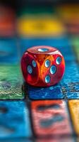 A red dice sitting on a colorful board photo
