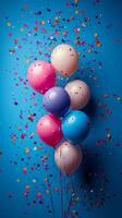 Colorful balloons and confetti on a blue background photo