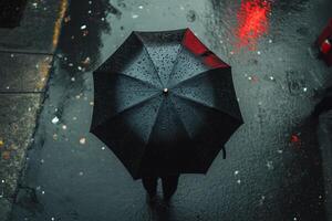A person holding an umbrella in the rain photo