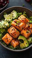 Salmon, avocado and sesame dressing on a dark background photo