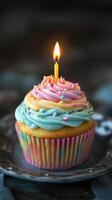 A cupcake with a single candle on top photo