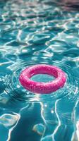 A pink life ring floating in a pool photo