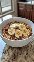 A bowl of granola with bananas, raisins and almonds photo
