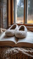 A pair of knitted slippers sit on top of an open book photo