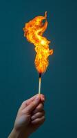 A person holding a matchstick with a flame coming out of it photo