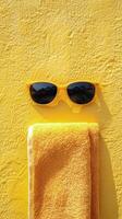 A yellow towel with sunglasses hanging from it photo