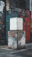 A white box sitting on a concrete block in front of a building photo