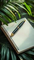 Pen and notebook on a palm leaf background 3d rendering photo