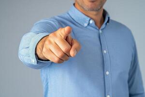 A man in a blue shirt pointing at something photo