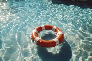 An orange life preserver floating in a pool photo