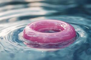 A pink ring floating in a pool of water photo