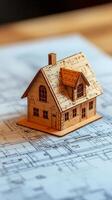 A small wooden house sits on top of a blueprint photo