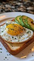 A piece of toast with an egg and avocado photo