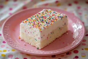 A piece of cake on a plate with sprinkles photo