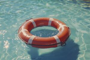 An orange life preserver floating in a pool photo