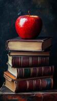 A stack of books and an apple on top of them photo