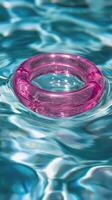 A pink ring floating in a pool of water photo