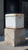 A white cooler sitting on a concrete block photo