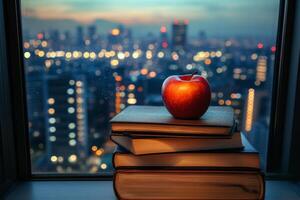 An apple sits on top of a stack of books photo