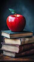 An apple sits on top of a stack of books photo
