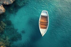 A boat floating in the ocean near a rocky shoreline photo
