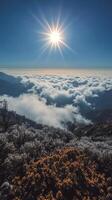 The sun shines over the clouds and mountains in this photo