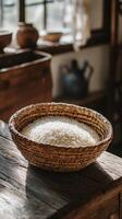 A bowl of rice sitting on a wooden table photo