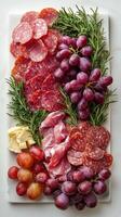 A platter of meat, grapes and cheese photo