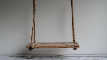 A wooden swing hanging from a rope photo