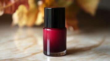 A bottle of red nail polish on a marble table photo