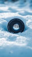A camera lens is sitting in the snow photo