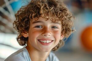A young boy with curly hair smiling photo