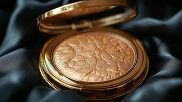 A golden compact powder compact on a black cloth photo