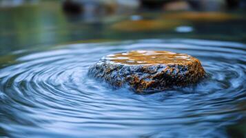 A rock in the water with a wave photo