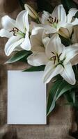 White lilies and blank card on burlock cloth photo