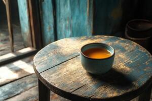 A cup of tea sits on top of a wooden stool photo