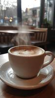A cup of coffee on a saucer with steam coming out of it photo