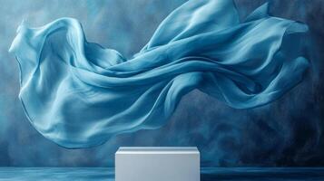 Blue silk flowing in the air over a white box photo