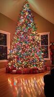 A large christmas tree is lit up in a living room photo