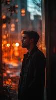 Man looking out the window at night photo