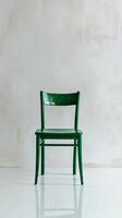 A green chair sitting in front of a white wall photo