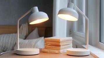 Two lamps on a table next to a book photo