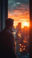 Man looking out window at sunset photo