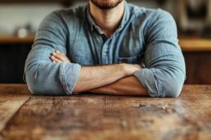 A man sitting at a table with his arms crossed photo