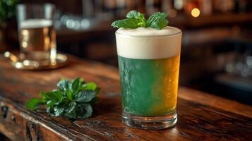 A beer with mint leaves on top of a wooden table photo